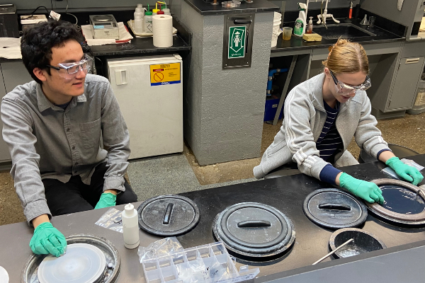 Two students working in lab with polishing tools