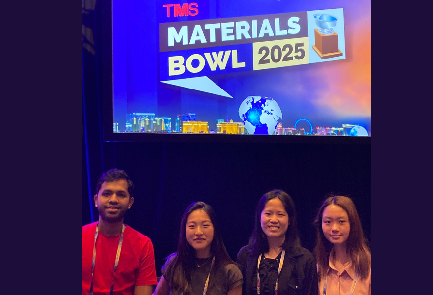Soup of students standing in front of Materials Bowl sign