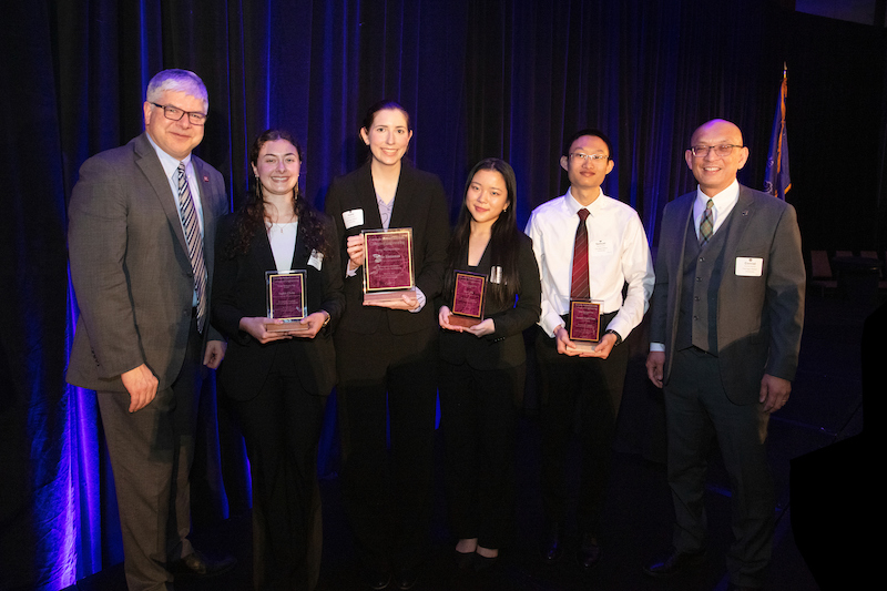 group of people holding awards