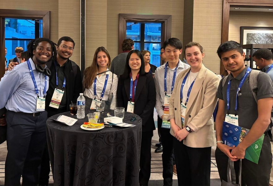 group photo of students standing at table
