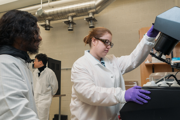 Two students using machine in lab